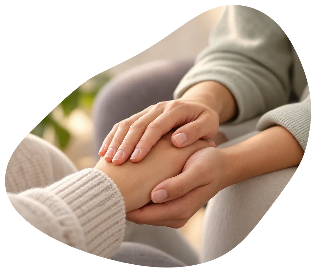 One person gently holding another’s hand in support